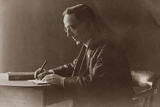 Black and white, old photo of a man’s side profile, writing a letter