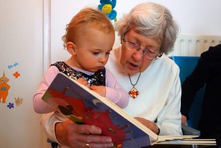 A grandmother reading to her child