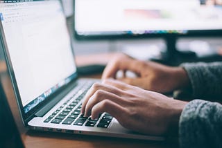 Man writing web content on a laptop