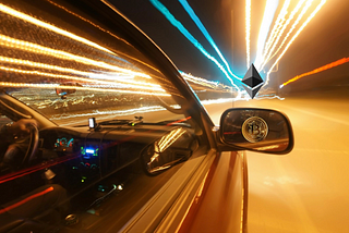Car driving fast with Bitcoin logo in side mirror and Ethereum logo on horizon