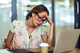 Frustrated female content creator looking at her laptop.