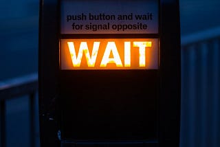 WAIT appears as a pedestrian illuminated sign