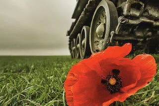 “A red poppy crushed underneath a tank tread, in a green field under a grey-white smoky sky” (Image generated by the author using ImageFX)