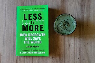 The book Less Is More by Jason Hickel and a matacha latte