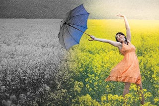 Woman with umbrella moving from dark, cold place into a sunny, warm place with flowers in background