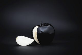 Black shadowed background with black apple and white slice cut out