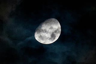 A captivating view of the gibbous moon shining through dark clouds in the night sky over Rio de Janeiro.