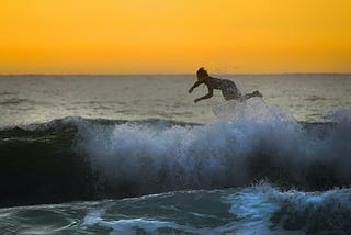 Woman flying off surfboard in the sea