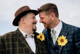 Two grooms looking at one another and smiling
