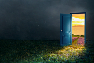 A door opening from the dark onto a sunlit meadow