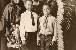 Here is a family from the Comanche Nation located in southwestern Oklahoma. The elder man in Comanche traditional clothing.