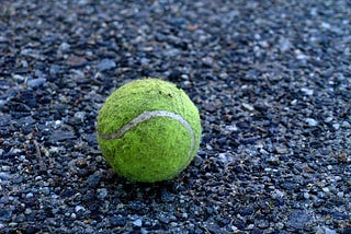 Old tennis ball on ground