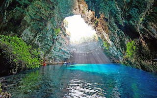 Beautiful cave with light coming through to shine on blue water