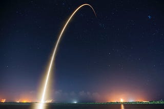 Night launch of a Space-X satellite showing a brilliant light trail against a dark sky