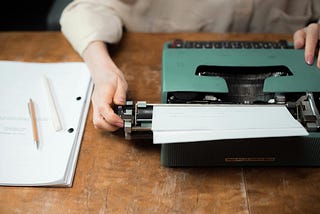 Writer adjusting a typewriter
