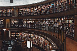 A curve shaped library with brown accents and thousands of books