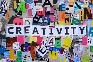 Colorful cutouts of letters compiled into a collage. On top of it are letters spelling out the word creativity.