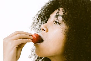 woman tasting a strawberry