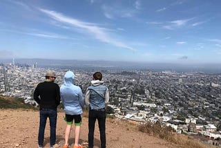 Three young men look over a city skyline