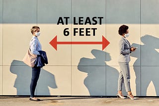 Two women practicing social distancing