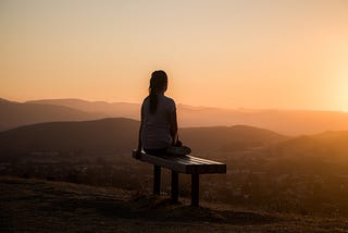 A girl looking at the sunset thinking about the reality