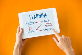 A person holding a white board that shows the flow of continuous learning or creative thinking