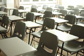 grey chairs and white desks in a classroom