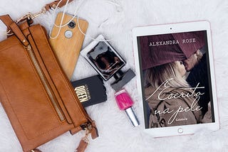imagem de uma bolsa saindo itens como celular, batom, perfume. Ao lado, um iPad com a capa do livro Escrito na Pele que tem um casal quase se beijando.