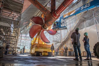 Workers observe a propeller installation for USS Nimitz at Puget Sound Naval Shipyard and Intermediate Maintenance Facility in Bremerton, Washington, October 16, 2018. Photo by Brian Kilpatrick/U.S. Navy