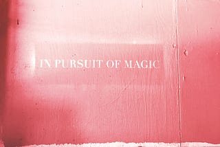 A pink screen with the quotation “In Pursuit of Magic”