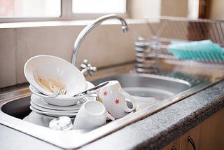 Kitchen sink full of dirty dishes