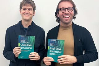 two men holding copies of a book they wrote