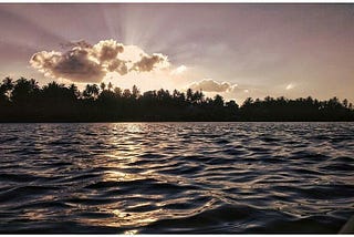 Beautiful sun rays, clouds and trees at the bank of the river, spending time on Sunday afternoon in Siri at Koti Kere, Karnataka.