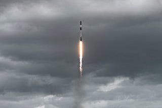 SpaceX rocket launching into storm clouds.