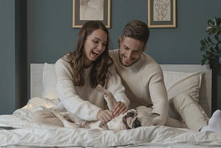 fur parents with dog in bed, What a Dog and a 117-Year-Old Theory Reveal About Conditioning in a Relationship