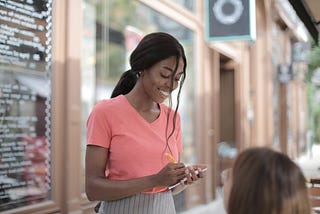 Photo of a black woman smiling while taking a customer’s order