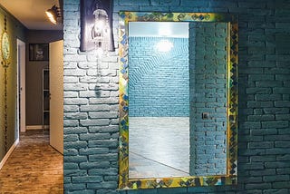 Mirror on blue brick wall