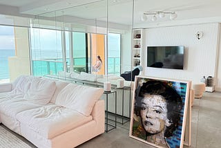A painting of Marilyn Monroe leaning against the wall of a condo