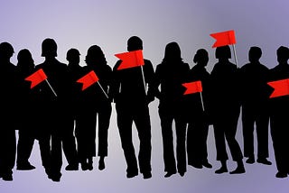 Silouettes of people with seven red flags over them.