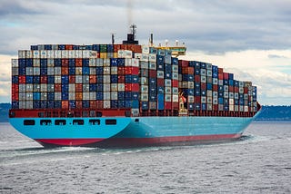 Blue cargo ship filled with containers.