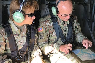 Two Army soldiers (including the author) in a helicopter reviewing maps as they fly over flooded parts of South Carolina following Hurricane Florence in 2018.