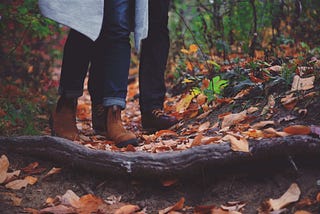 two pairs of boots, walking together in the forest