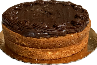 A yellow layer cake with chocolate frosting on the top only.