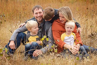 Family sitting in a brown field