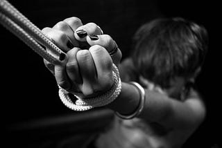 black and white picture of a woman tied on a rope