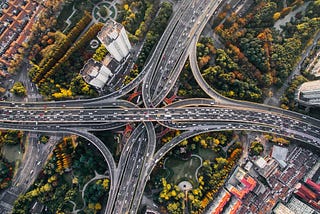 Aerial photo of a freeway junction surrounded by trees and vegetation