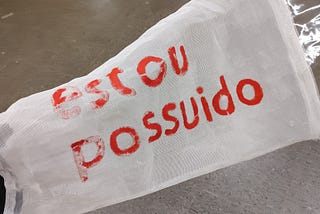 Parangolé de Helio Oiticica com a frase “estou possuído”.