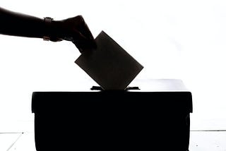Picture of vote going into ballot box.