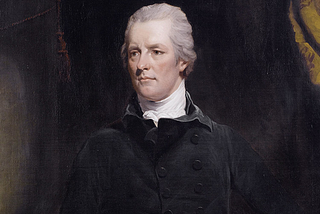 William Pitt the Younger: a man dressed largely in black, against a dark background, with swept-back white/grey hair, looks off to the left of the image as if thinking significant thoughts about the state of the country