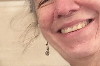 a woman of a certain age (me) smiling at you